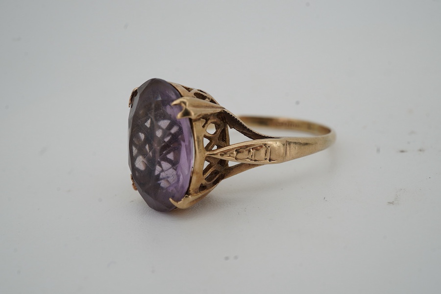 An amethyst ring and a pendant, the ring set with an oval amethyst, mounted in 9ct gold, size N, British hallmarks; the pendant modelled as an archer, length 3.6cm